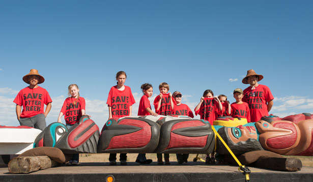 Members of the Northern Cheyenne nation stand over a totem pole crafted by Lummi master carver Jewell James as part of a protest against Powder River Basin coal extraction. Photo by Paul K Anderson.